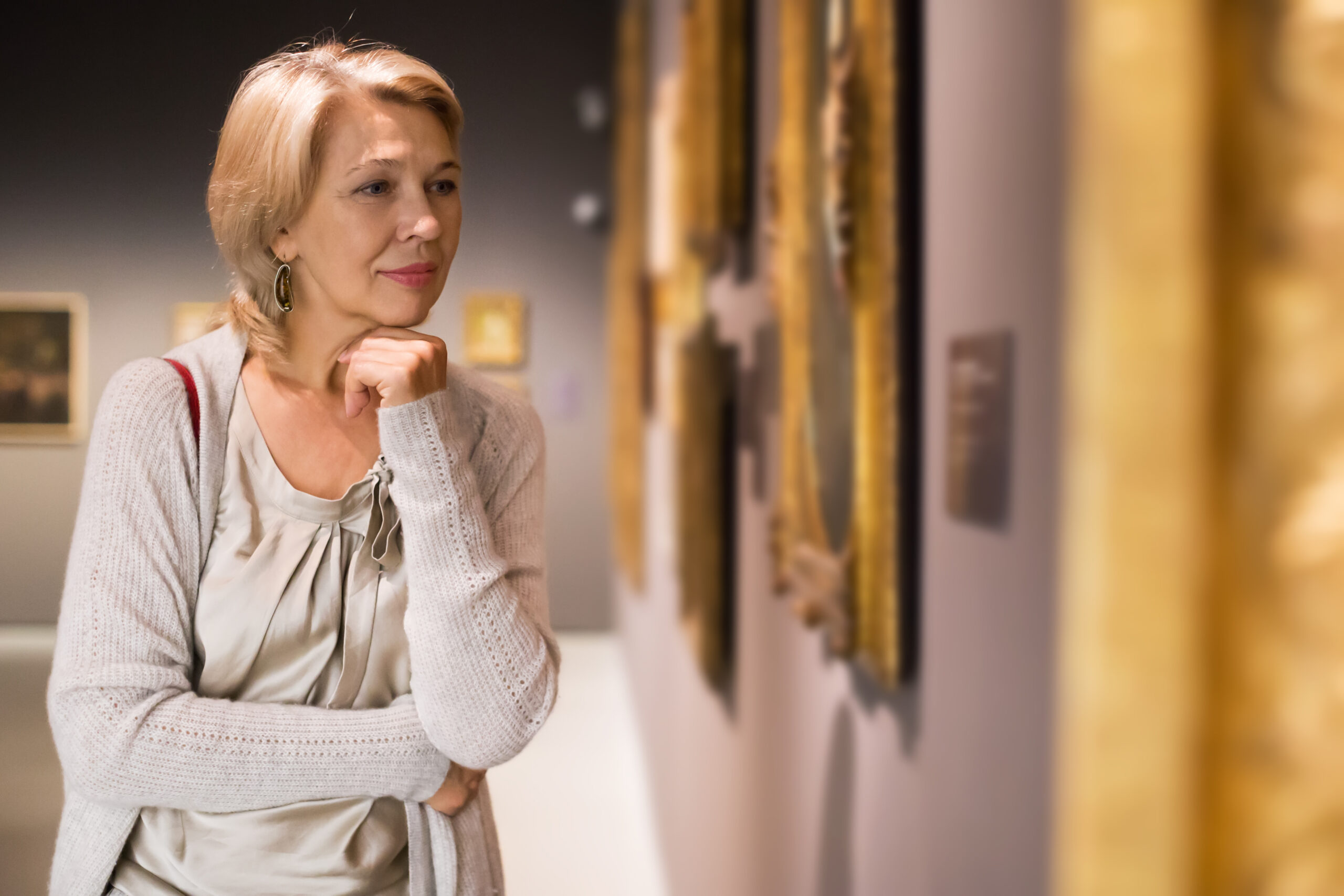 How to donate art when downsizing - woman near picture collection in a museum
